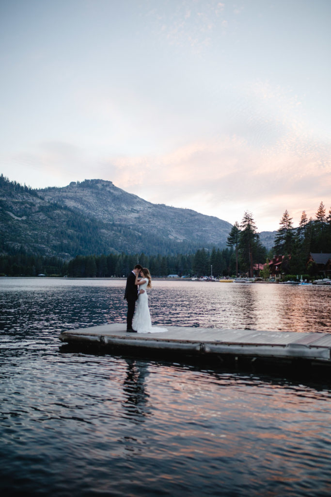 bride and groom standing on a dock on a lake in Tennessee holding each other on their elopement day