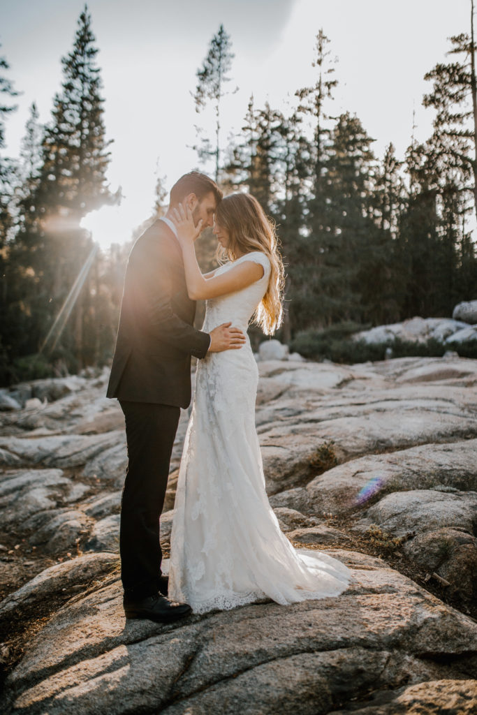 husband and wife, bride and groom embracing eachother in the fall on a mountain during a boho forest wedding