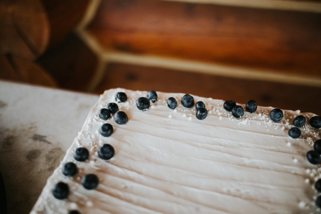 Up close detail shot of a wedding cake, covered in crystal sprinkles and blueberries.