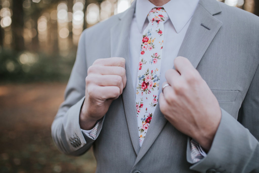groom wearing floral tie in forest bridals