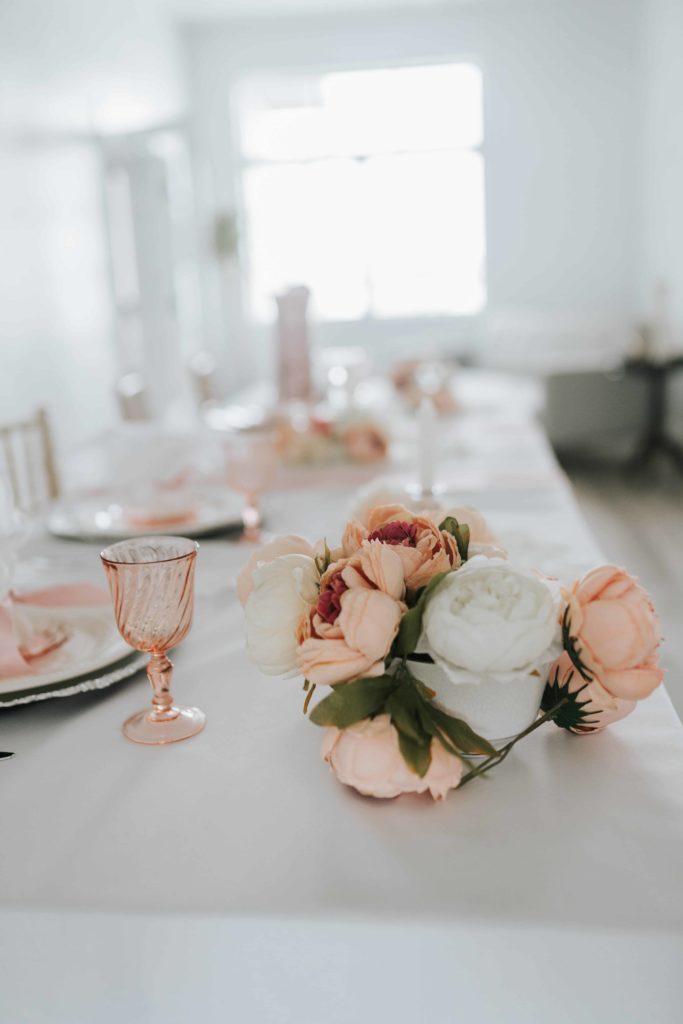 pretty pink wedding table settings with dusty pink roses and white table cloth