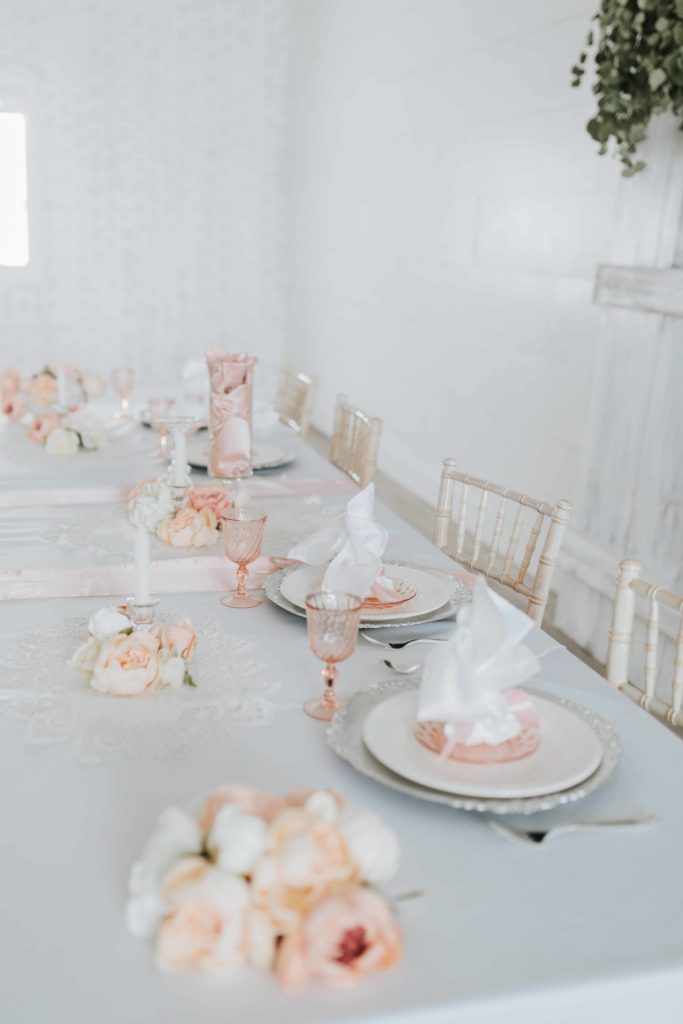 white an d pink wedding table lay. pink roses with white table runner and pink dishes. Elegant and classy pink wedding