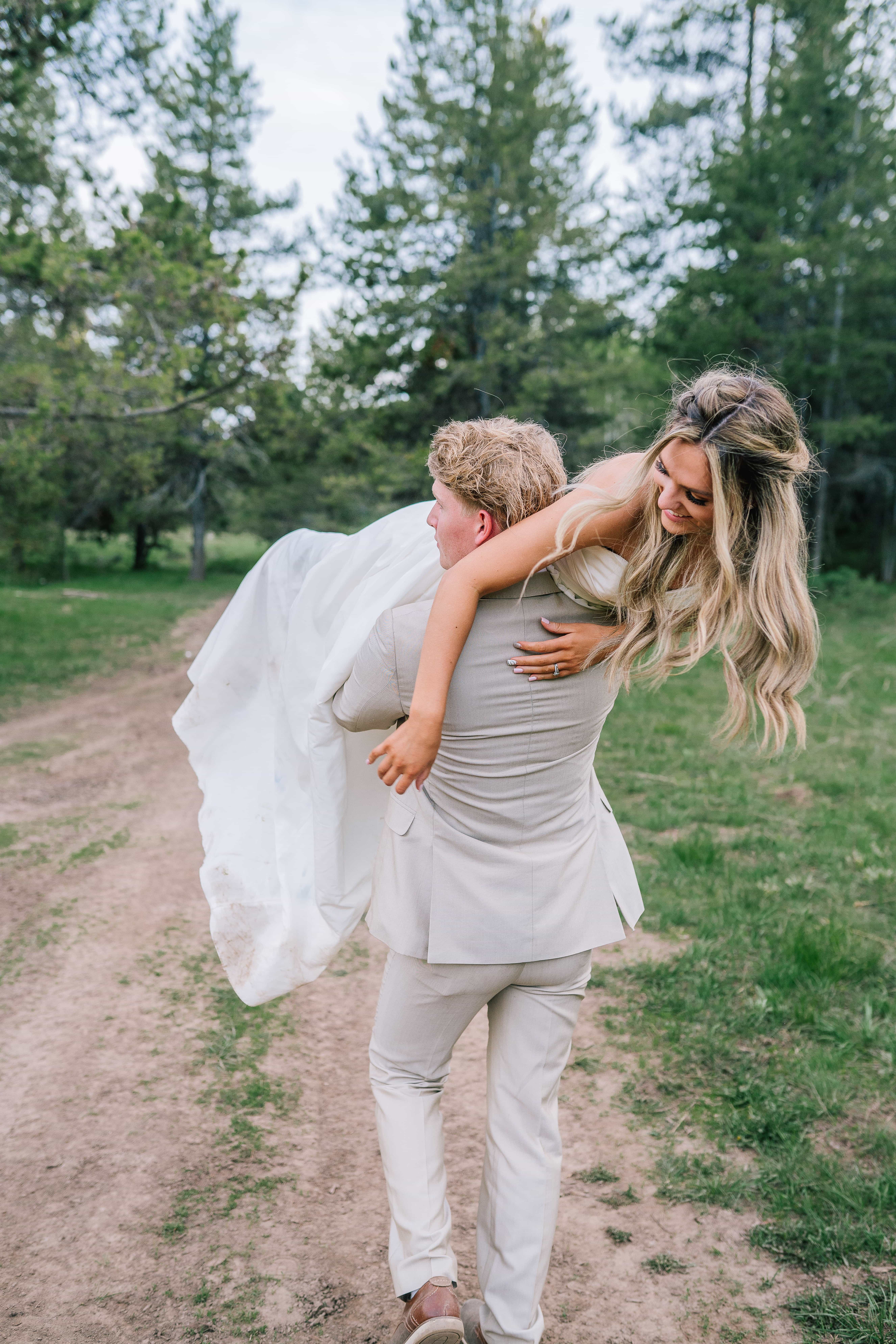 groom carrying bride off into the forest after getting married in tennessee budget friendly wedding after choosing top wedding planner