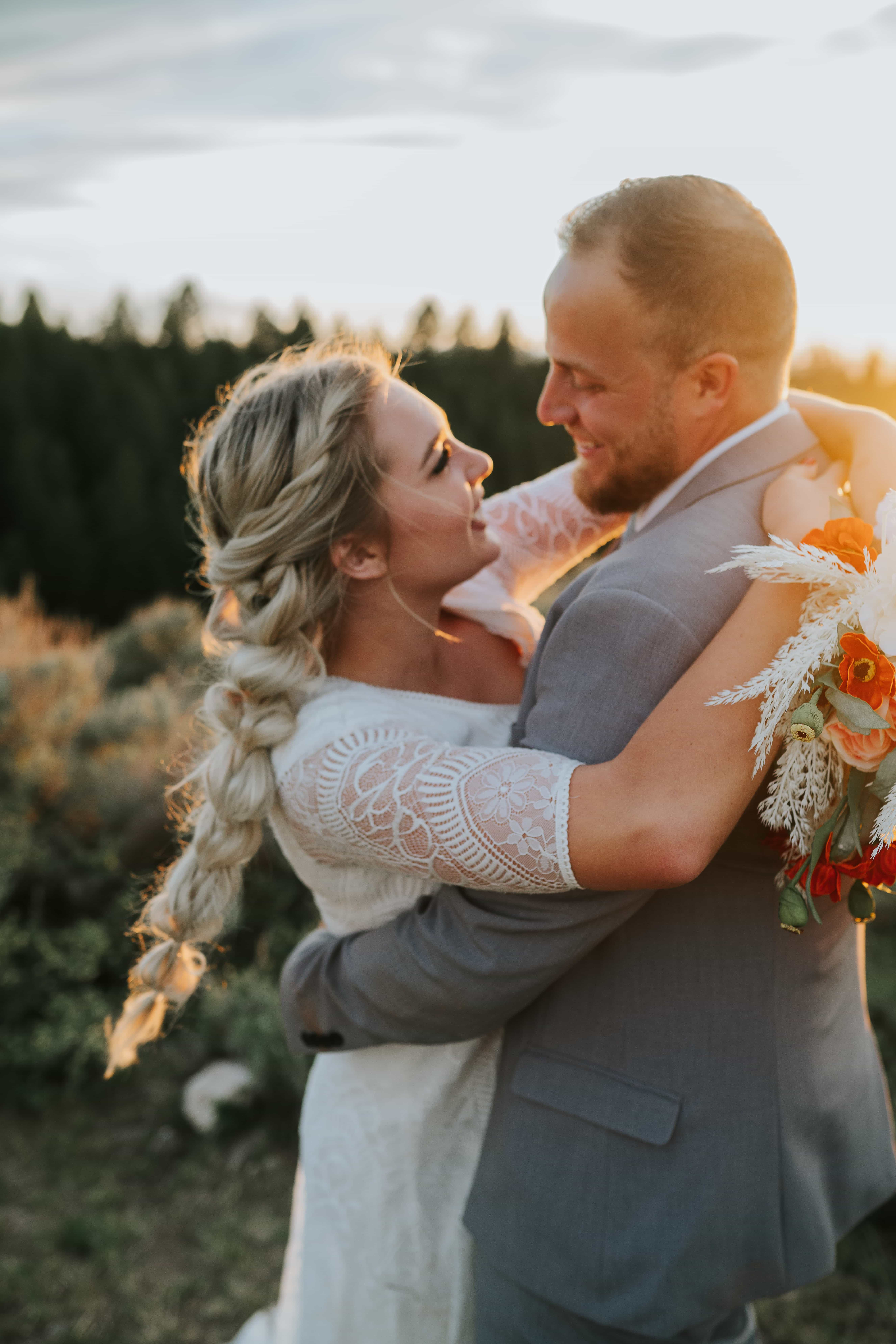 Sacramento wedding photographer captures bride and groom outside embracing while holding her flowers after choosing knoxville wedding planners for their day
