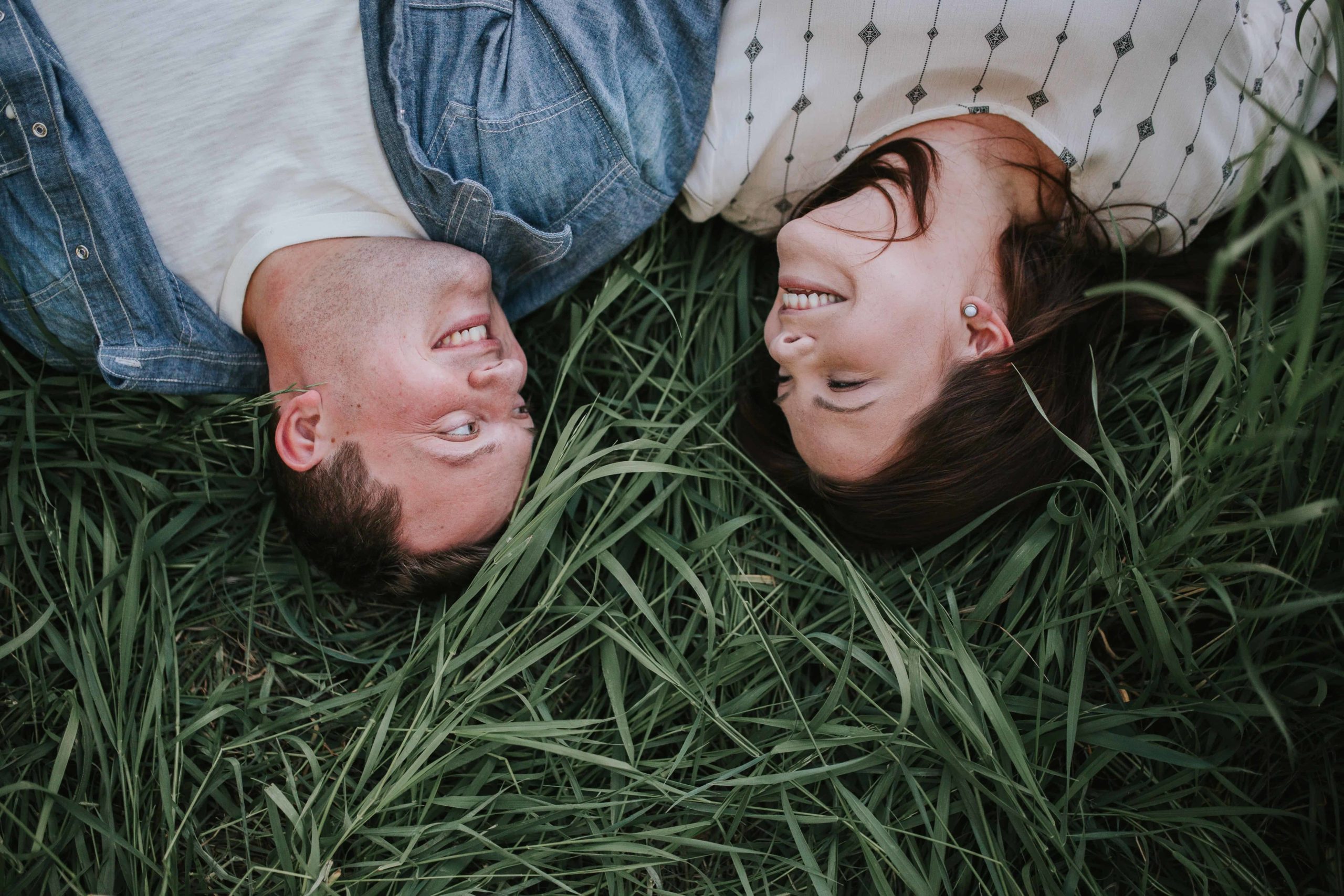couple laying in tennessee grassy field during engagement session
