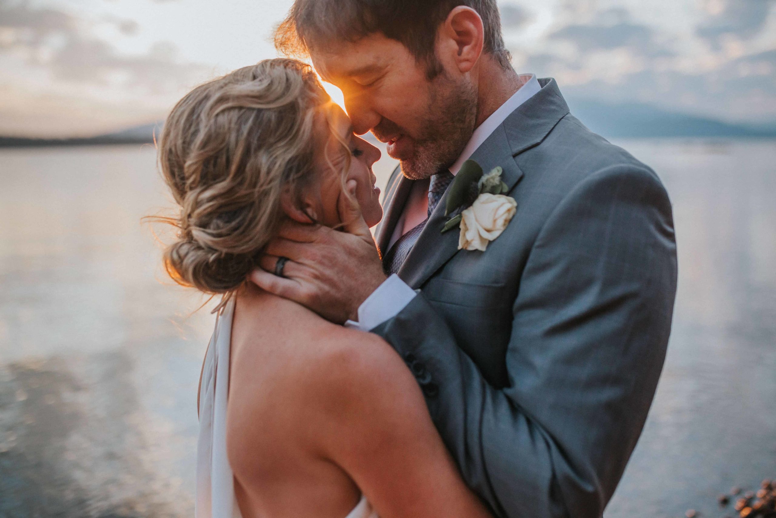 groom holding bride's face while hugging and celebrating adventure elopement budget friendly wedding