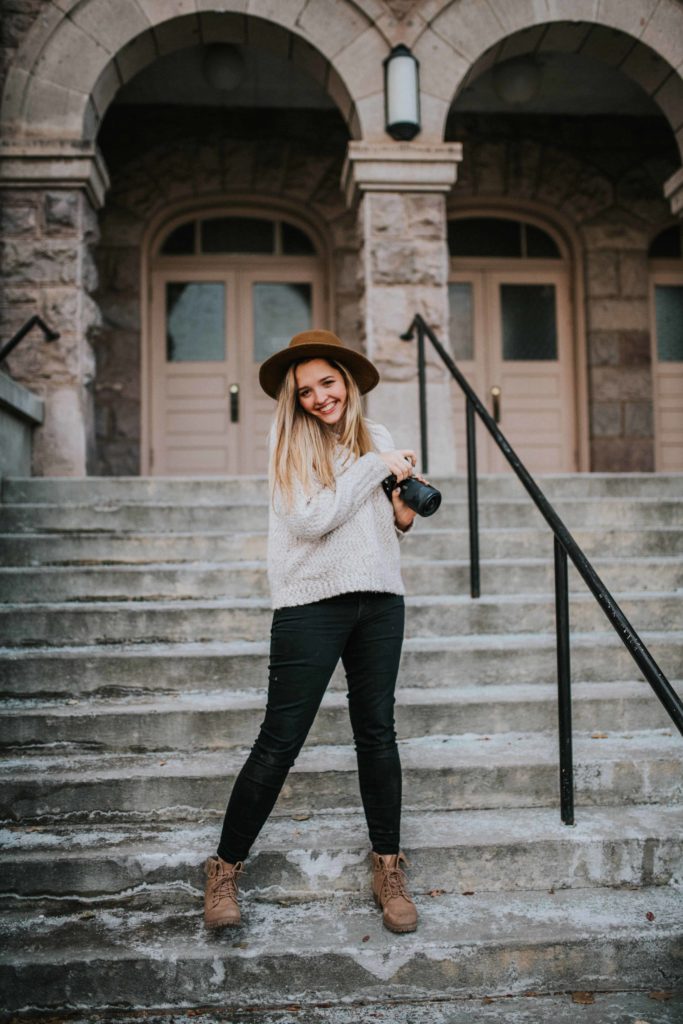 Woman wearing a brown hat standing on stairs in Knoxville while learning about how to grow instagram following