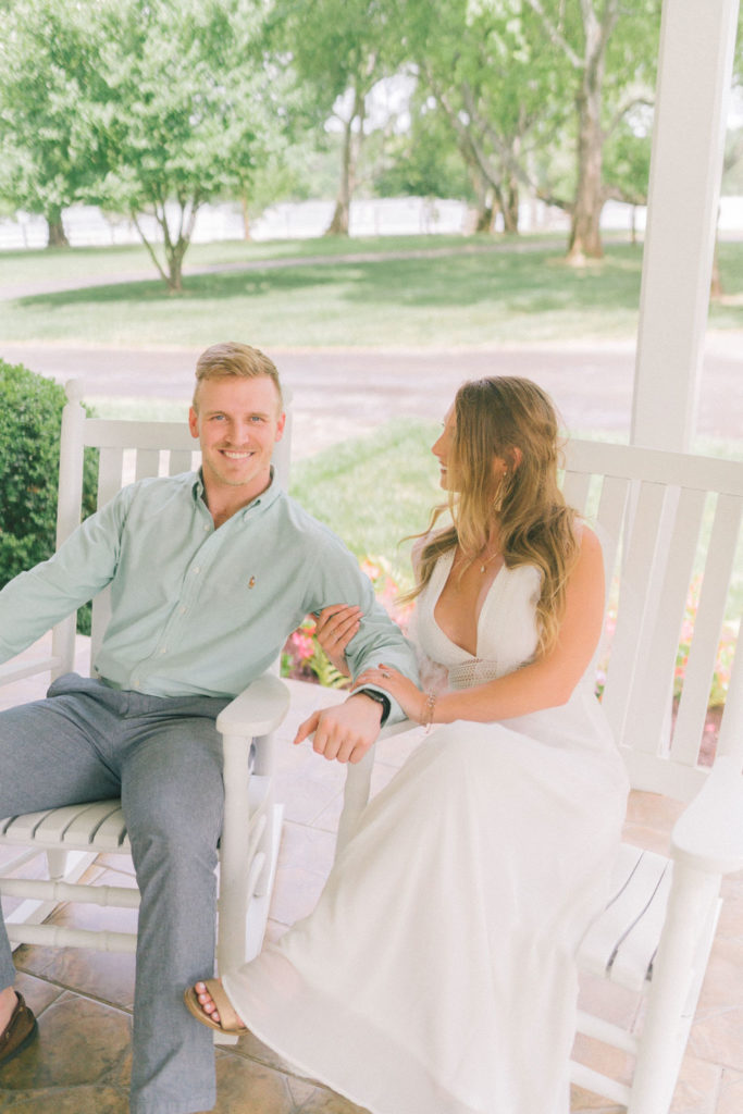 bride and groom sitting on rocking chairs on a southern porch holding hands in Knoxville Tennessee