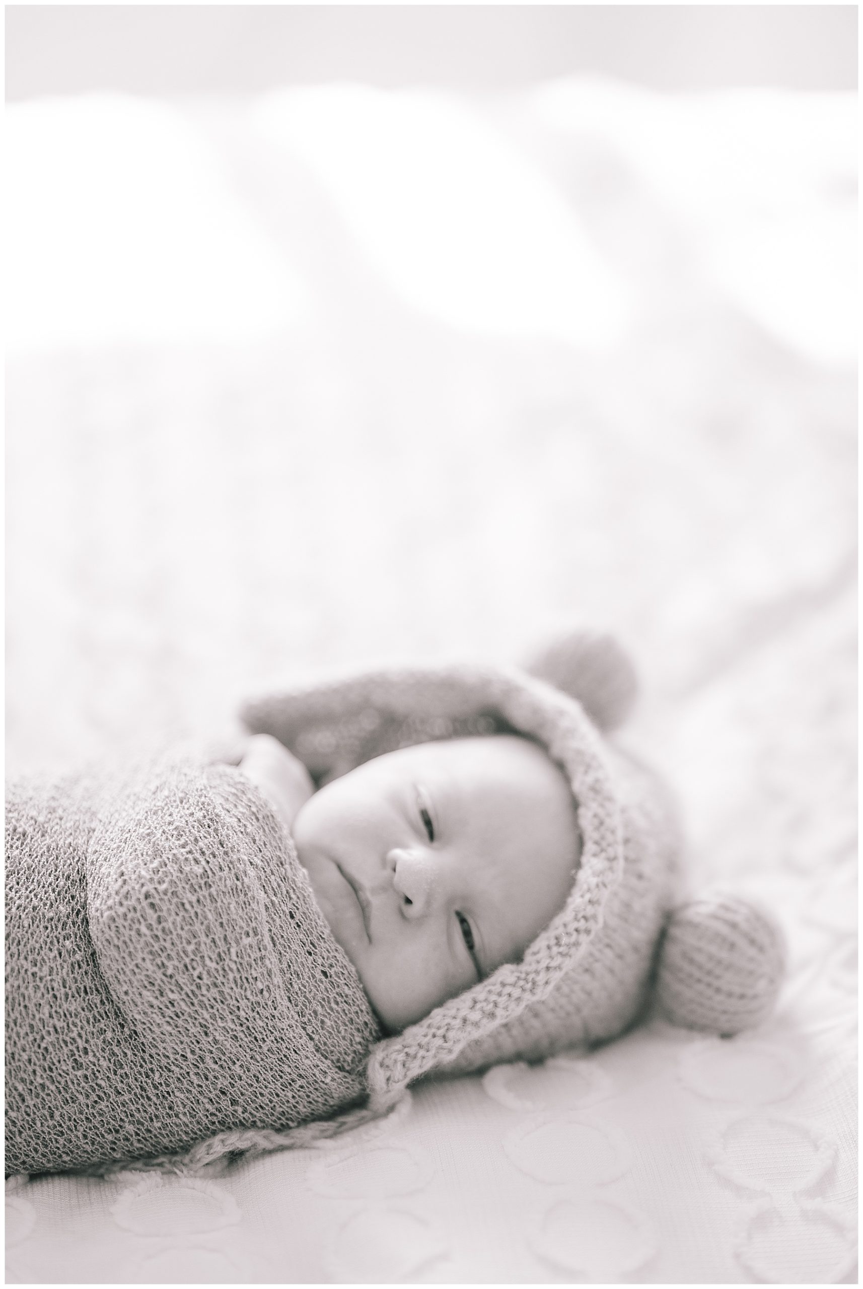 black and white photo of a baby boy for a newborn session, baby is swaddled ina wrap