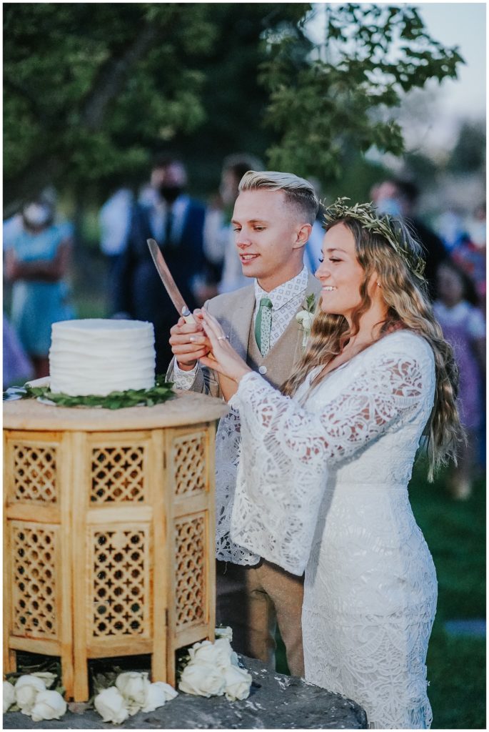 bride and groom cutting their boho wedding cake