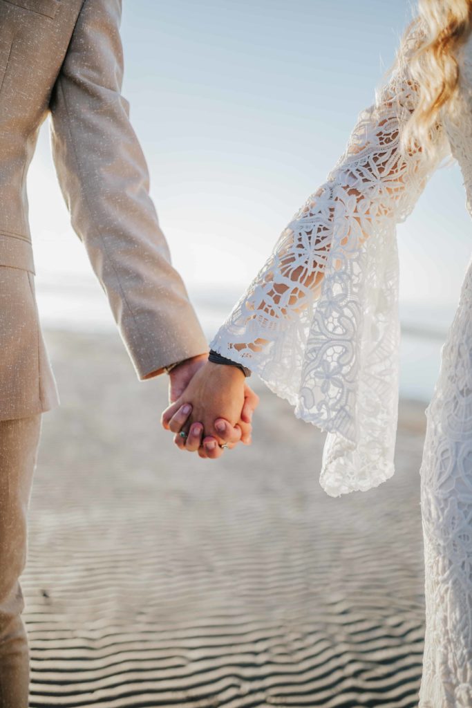 bride and groom holding hands during a boho wedding elopement in outer banks wedding