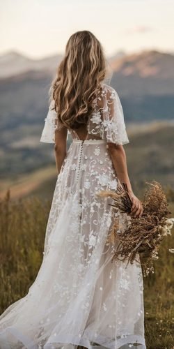 bride wearing intricate wedding gown with floral lace holding bouquet