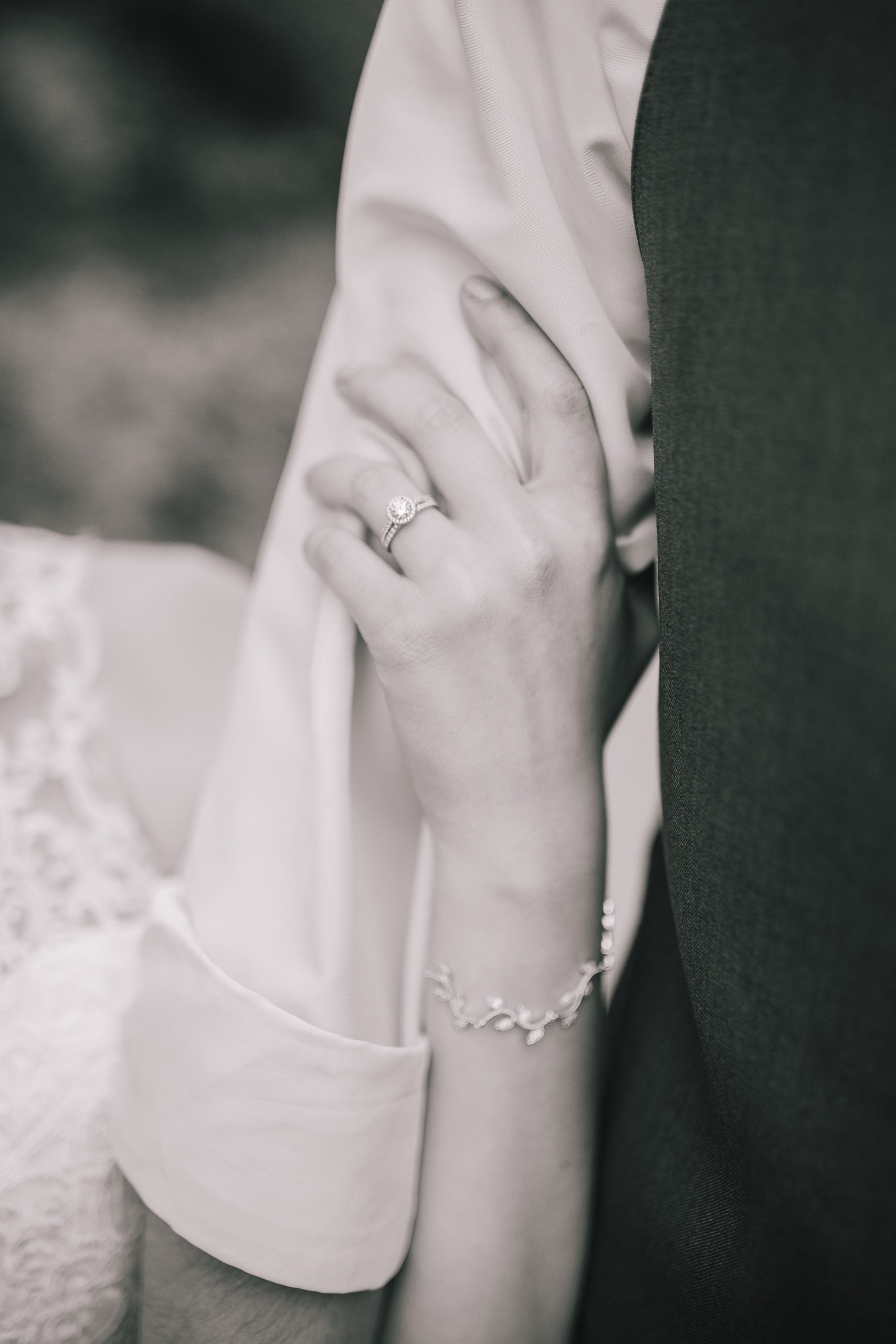 black and white photo of a detail shot of the wives ring and bracelet celebrating after planning budget friendly wedding