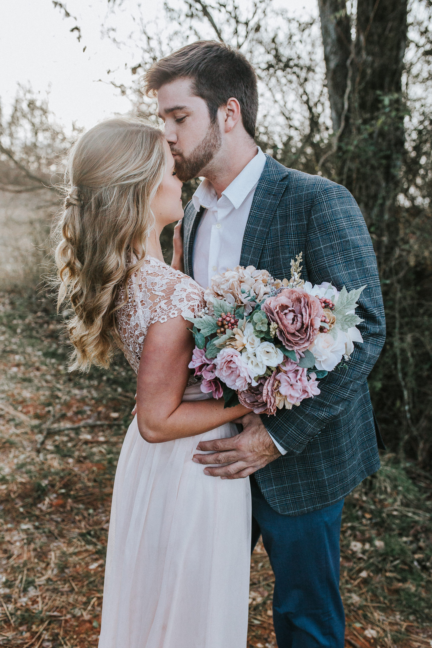 fall bridal in Tennessee, husband holding his wife and kissing her on the forehead after planning budget friendly wedding