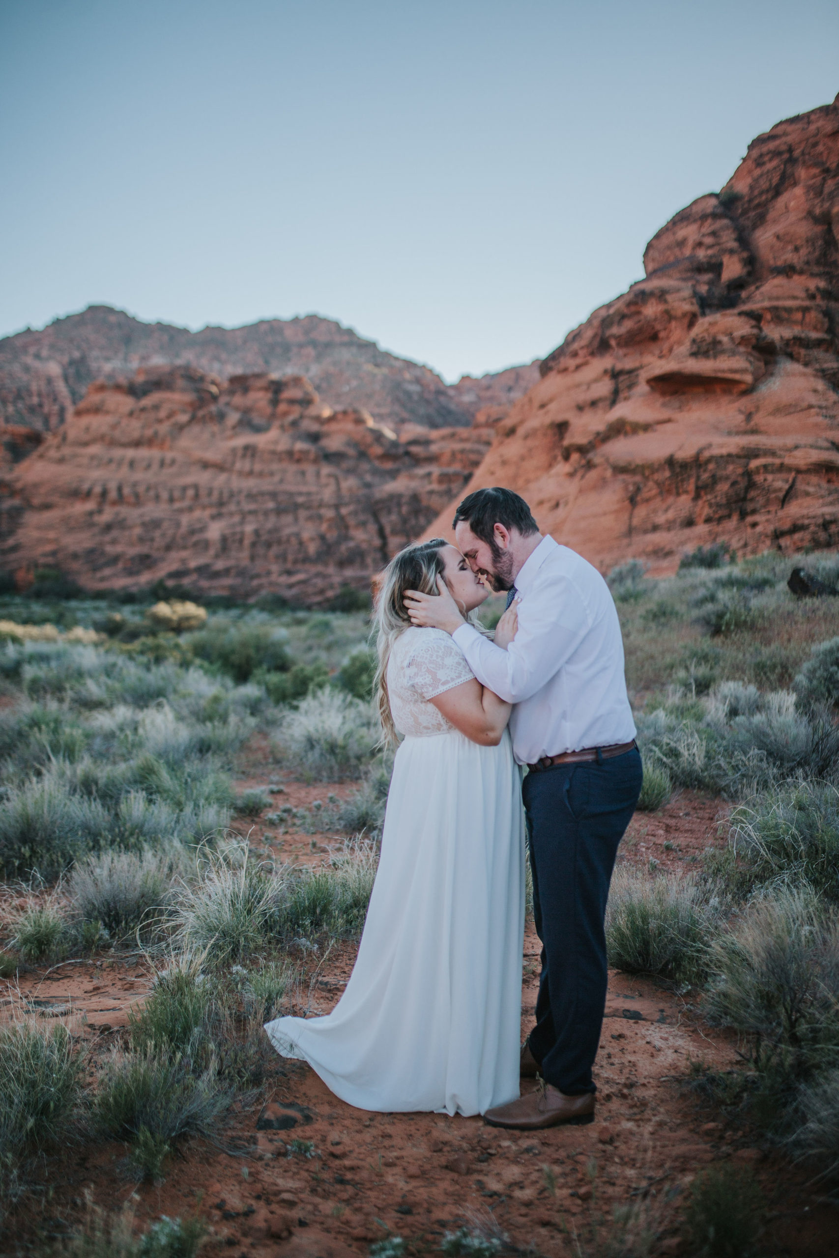 bride and groom kissing in the dessert