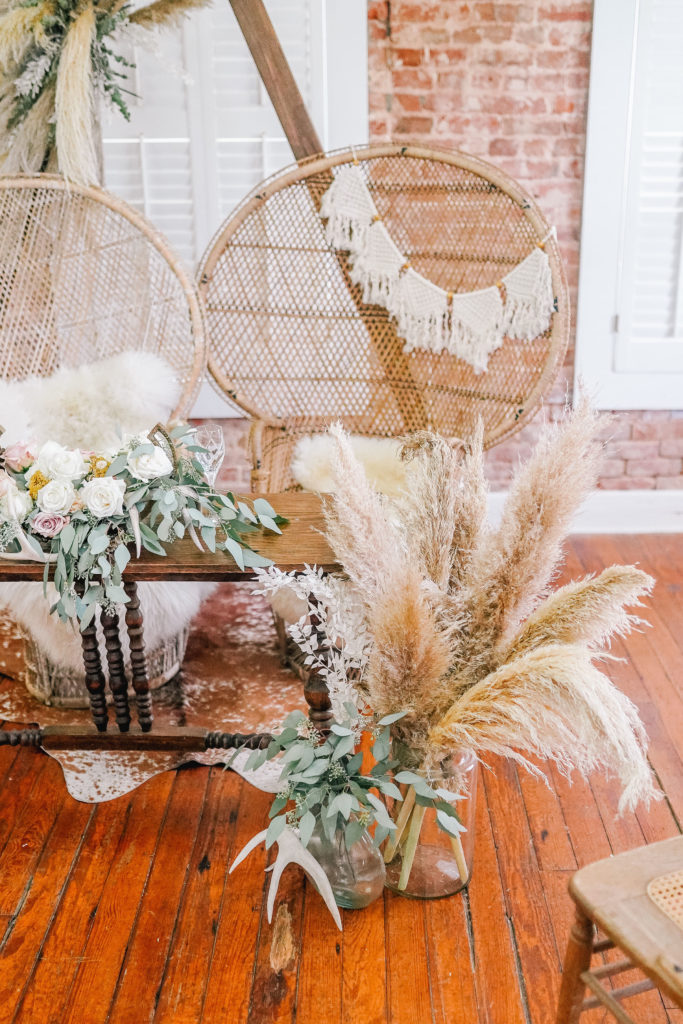 rustic and boho wedding decor with wicker chairs and macrame garland 