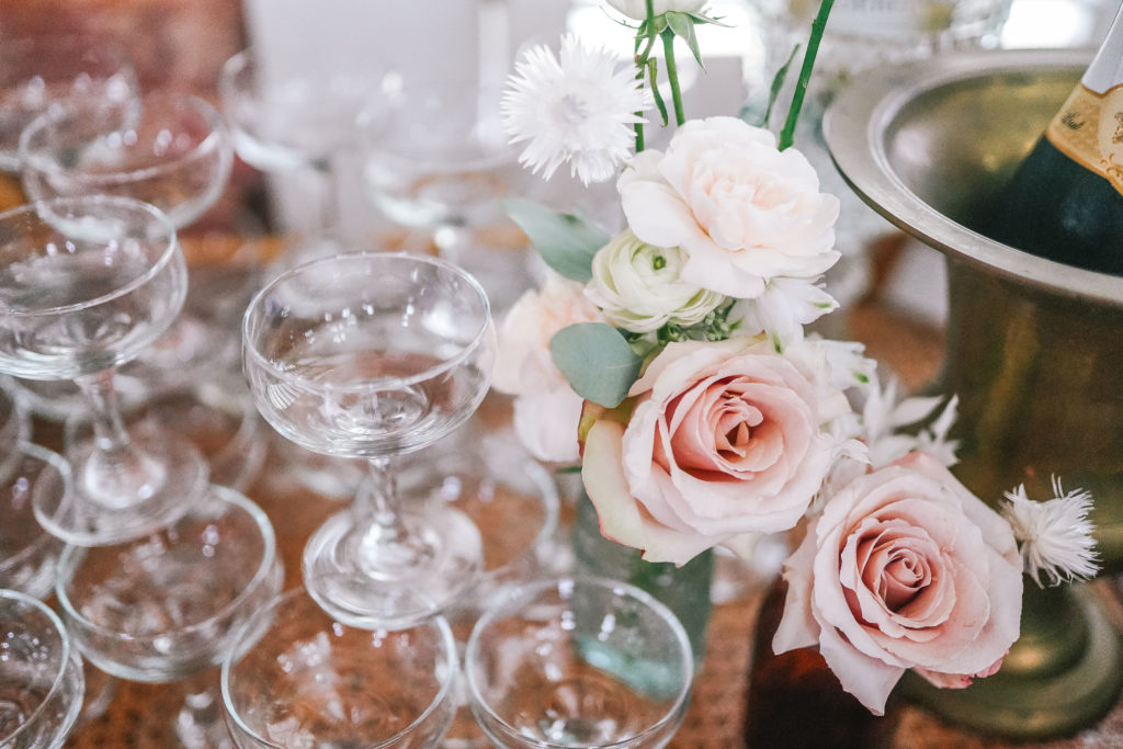wedding detail shot of champagne glasses and pink roses 