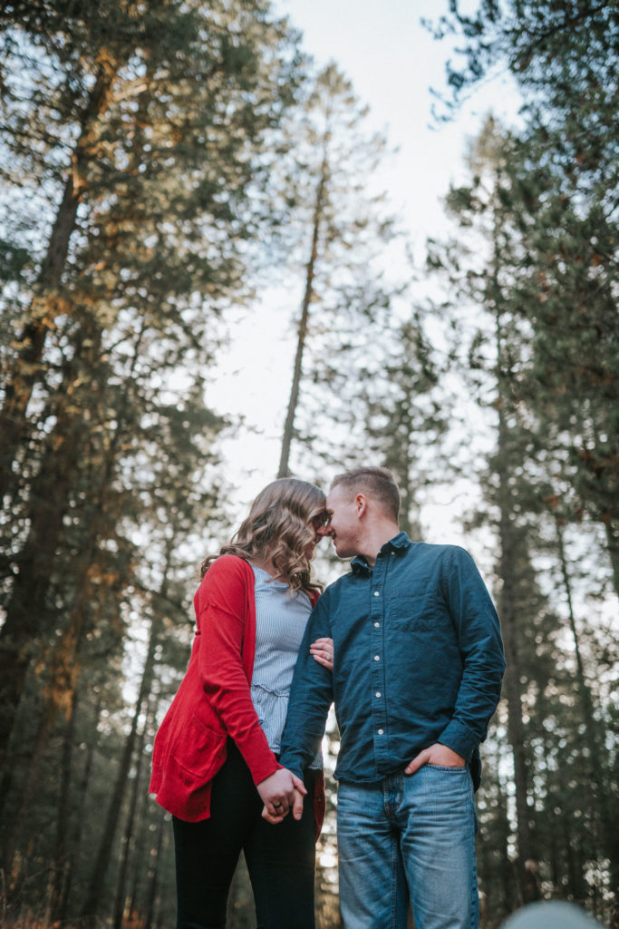 man and woman holding hands and kissing in tennessee forest engagement session