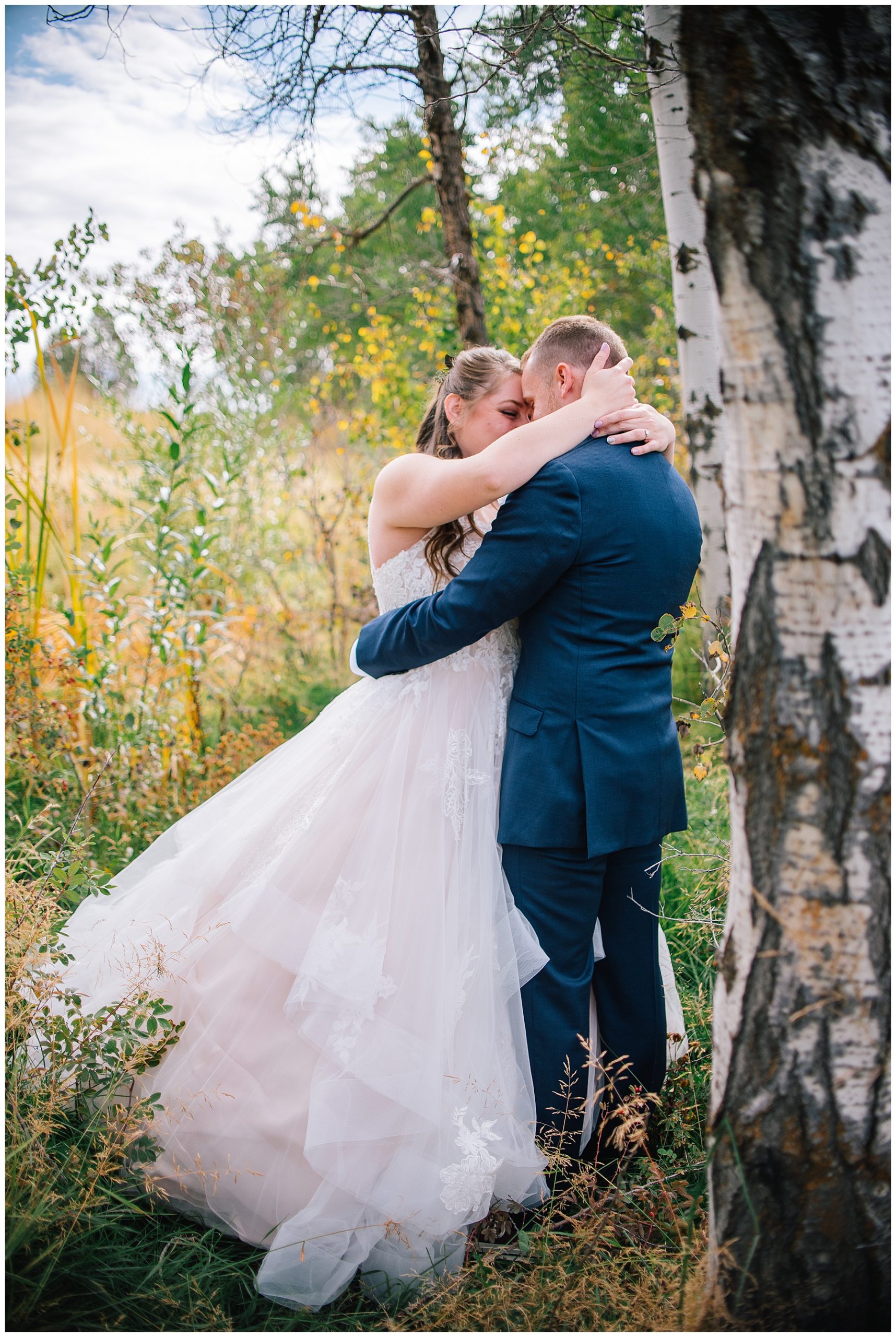bride and groom in the woods in the fall for their wedding day