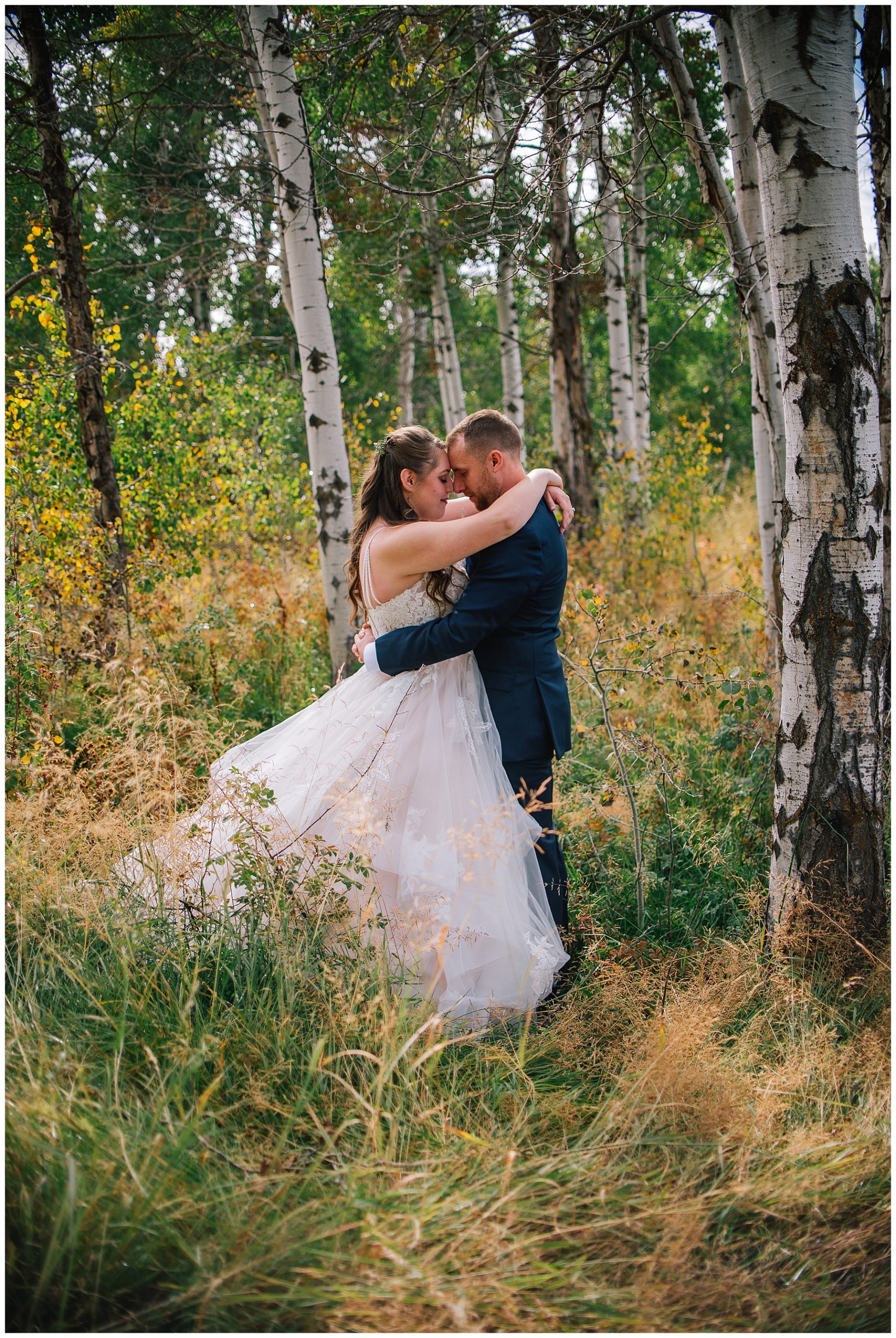 bride and groom hugging in forest of Grand Tetons mountains