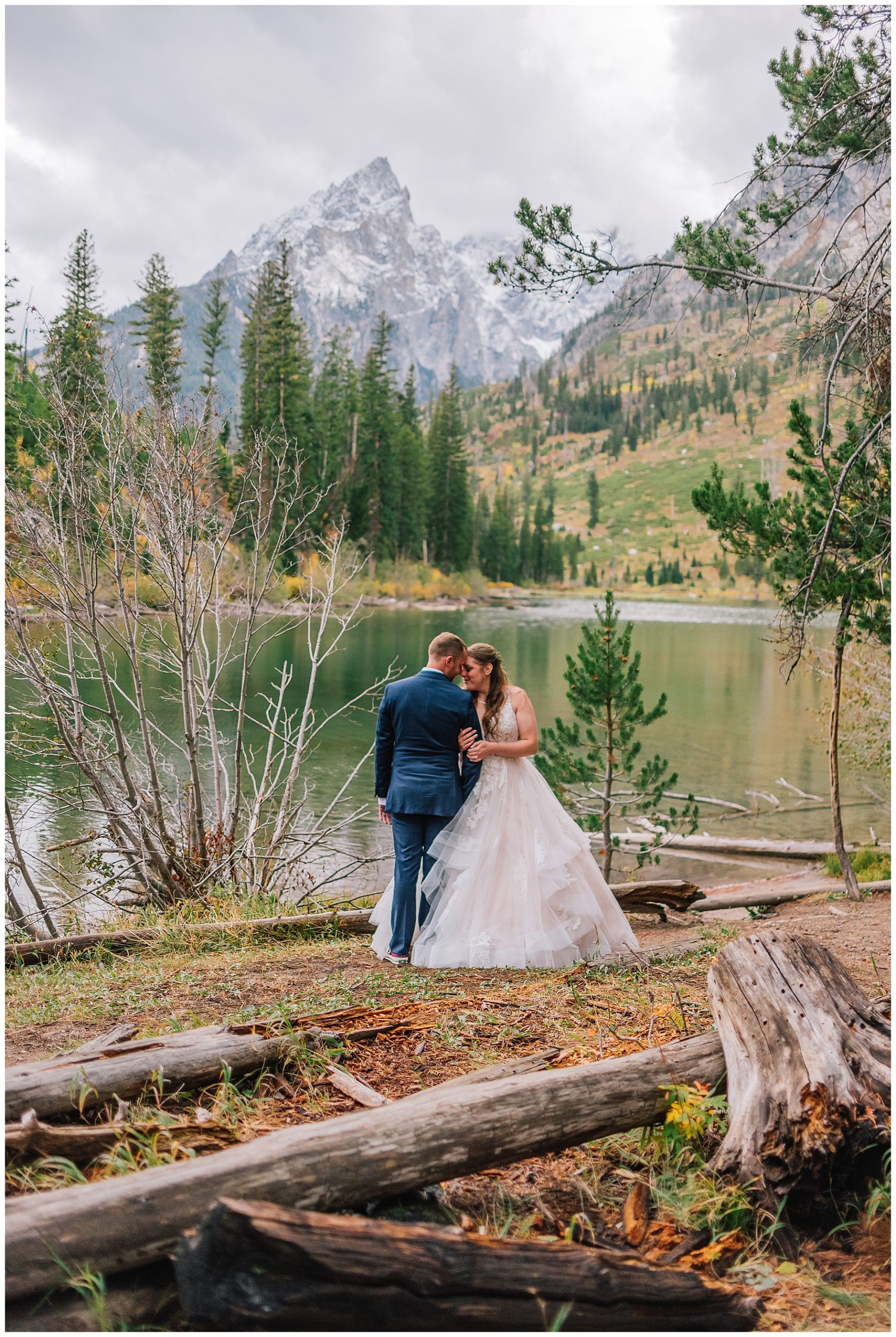 bride and groom hugging after recent marriage in front of pond