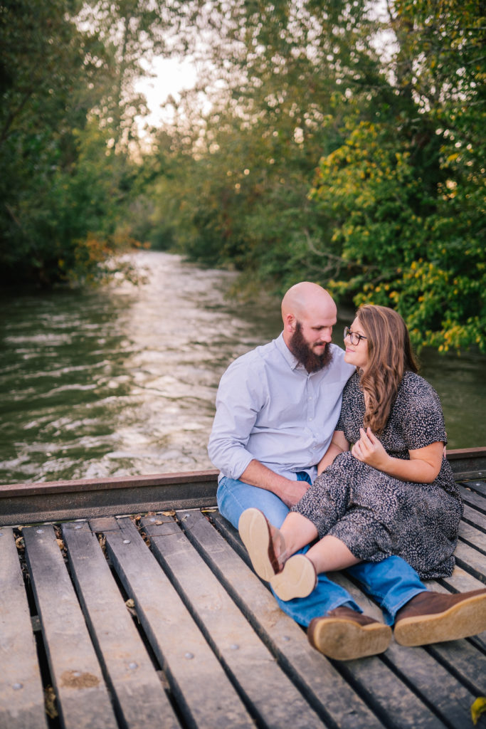 gorgeous brown bridge over a pond in Tennessee with a couple sitting together for an engagement session