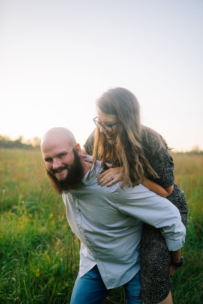 engaged couple piggy back riding in Knoxville Tennessee for a fall engagement session