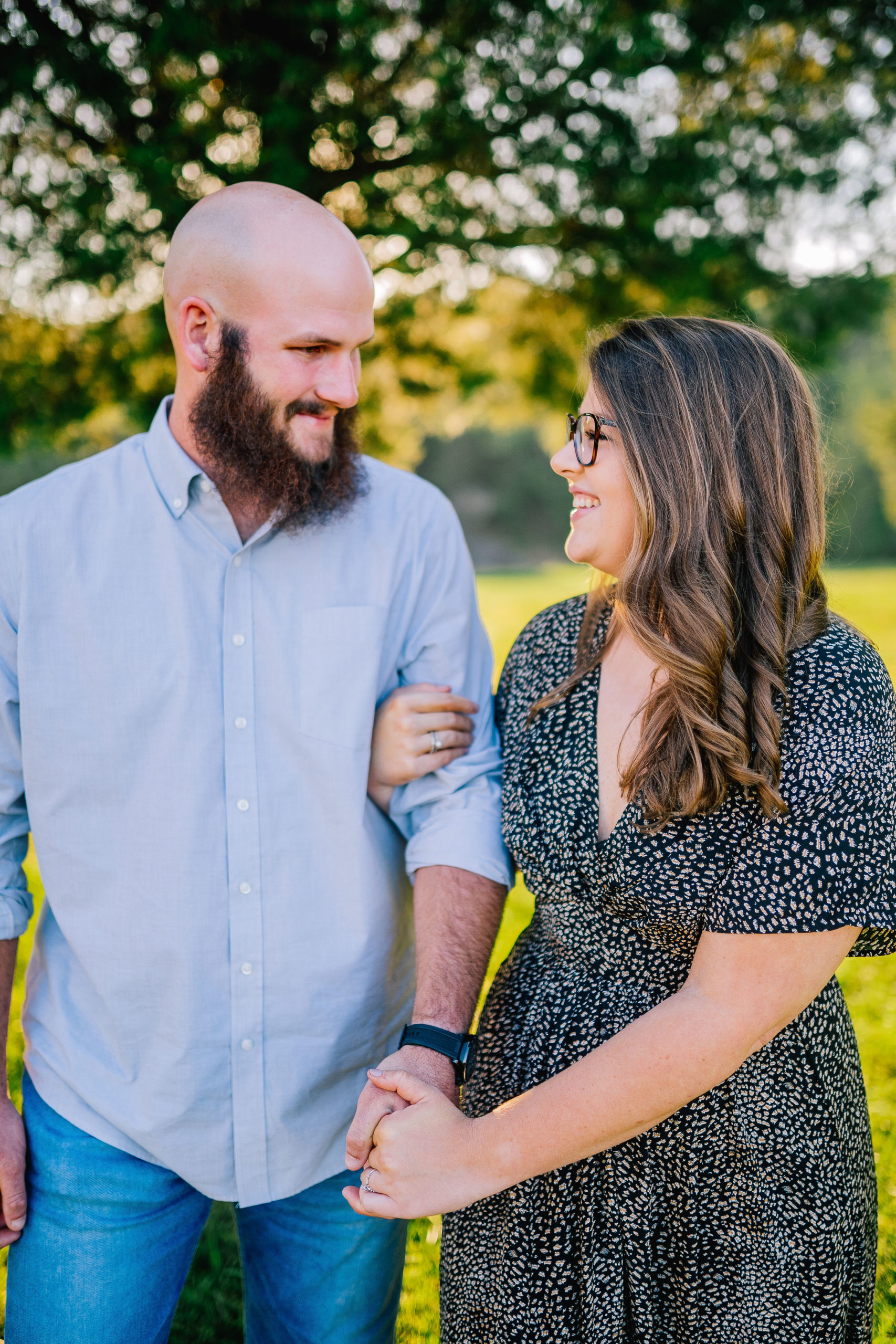 woman holding her mans arm and hands while walking along Seven Islands Birding Pond in Tennessee for a beautiful and classy engagement session