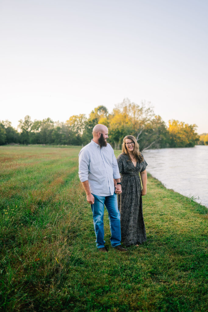man looking at his fiancé next to a lake at sunset for an engagement session Knoxville engagements