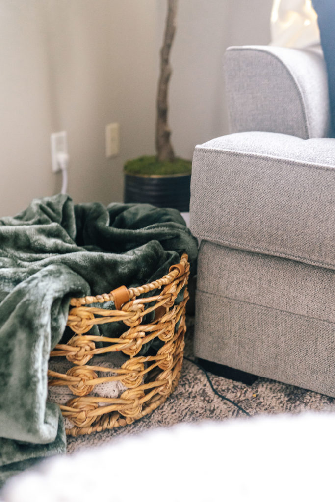 wicker basket with a lush green throw blanket inside in a Knoxville living room