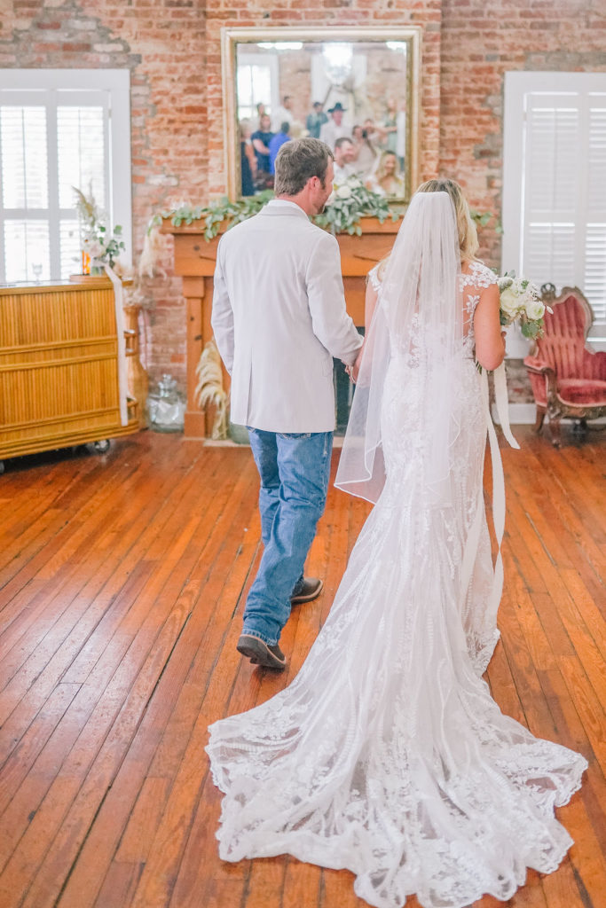 groom walking out his bride from their ceremony. Elegant boho inspired Louisiana wedding.