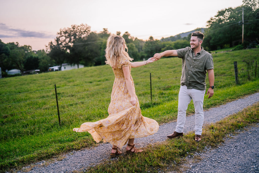 man and woman dancing in tennessee field during engagement session