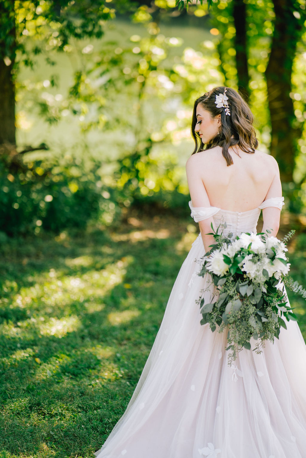 bride holding her floral arrangement behind her back outside