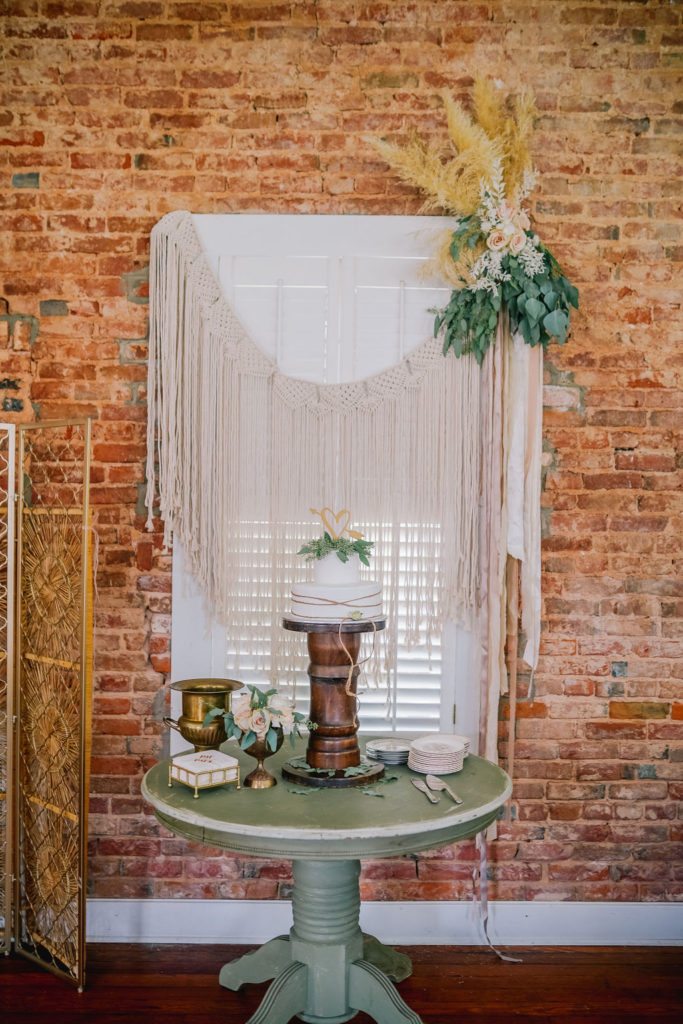 Bohemian inspired cake and decor with a brick wall