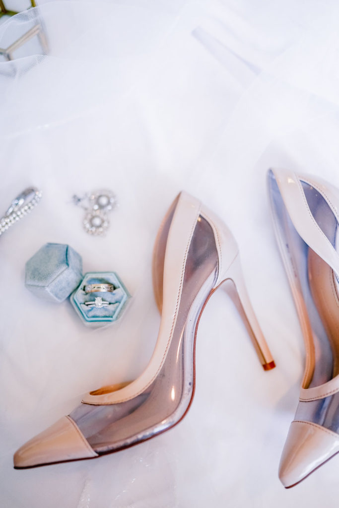 Flatlay of brides heels and jewlery for her wedding day. Elegant bridal lay after choosing wedding planner