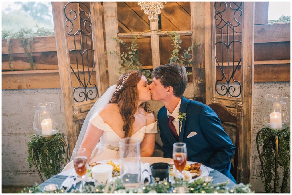 bride and groom kissing on wedding day during reception celebrating
