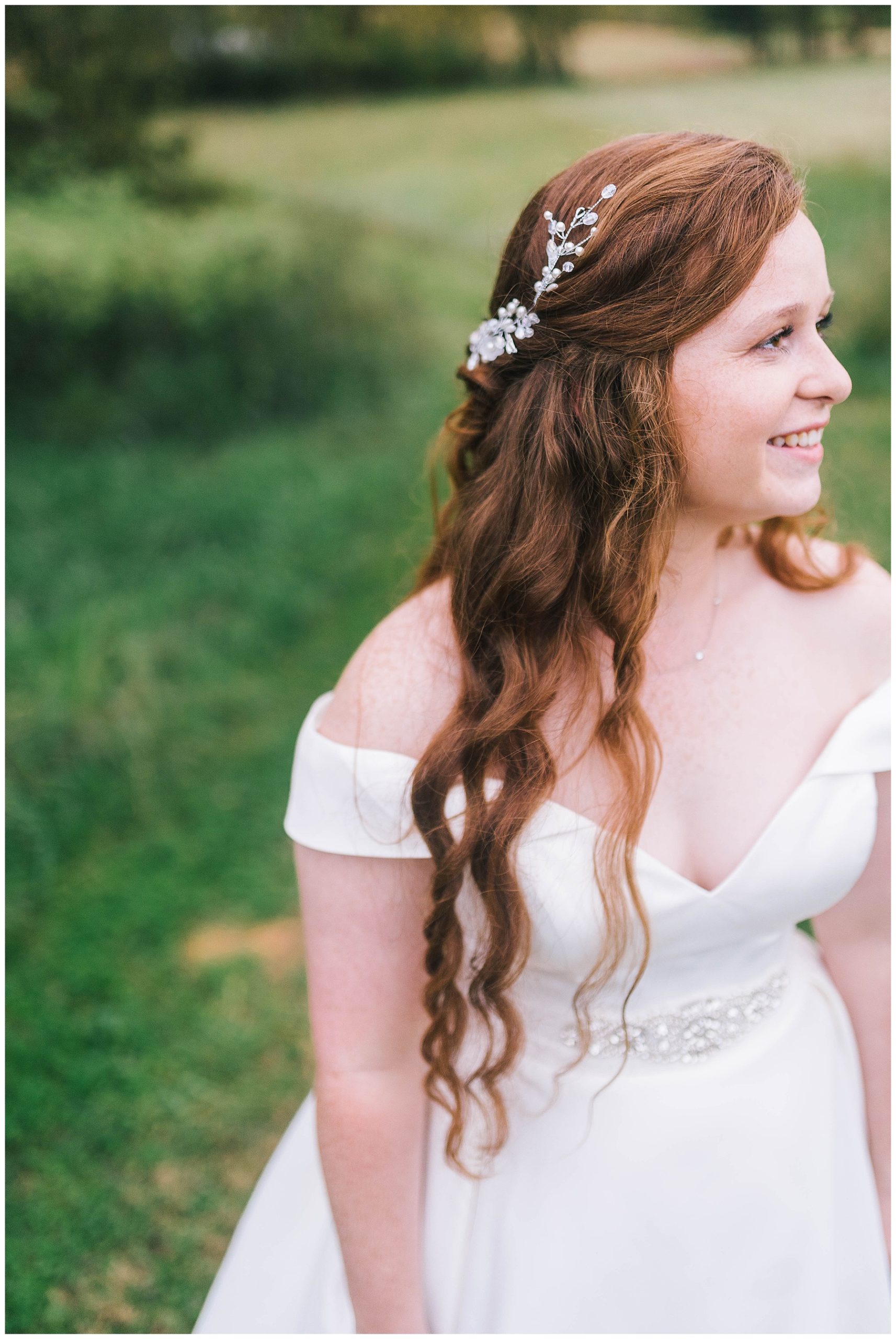 Red head bride in a off the shoulder satin gown smiles in Tennessee at her wedding