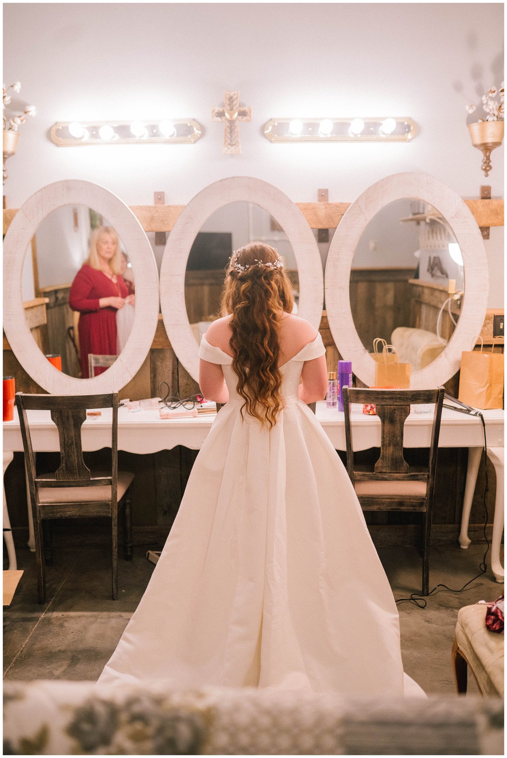 bride looking in beautiful mirrors in wedding dress for first time on wedding day in tennessee
