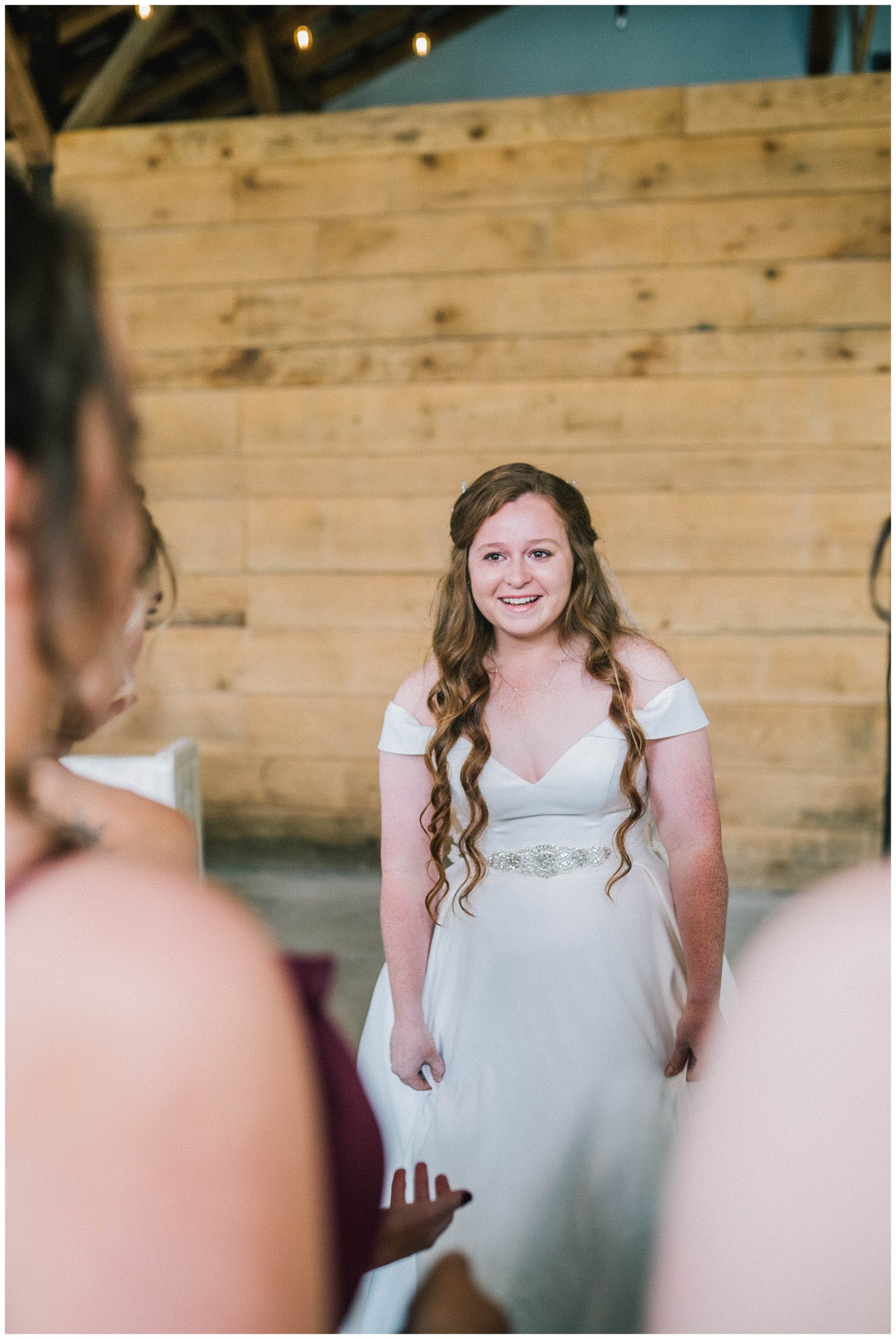 bride seeing her bridesmaids for the first time in wedding gown