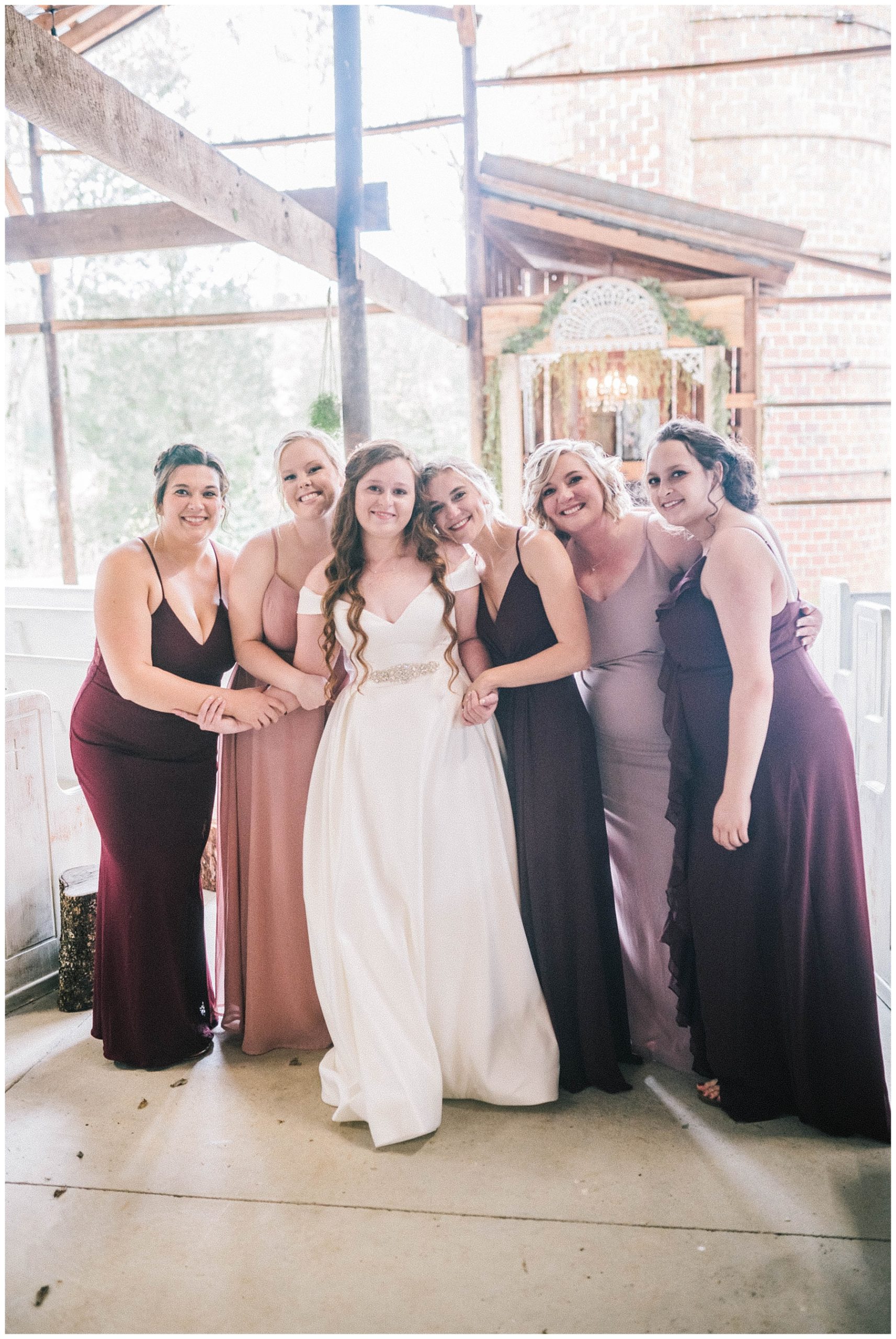 bride hugging all her bridesmaids on wedding day in knoxville at butler farms