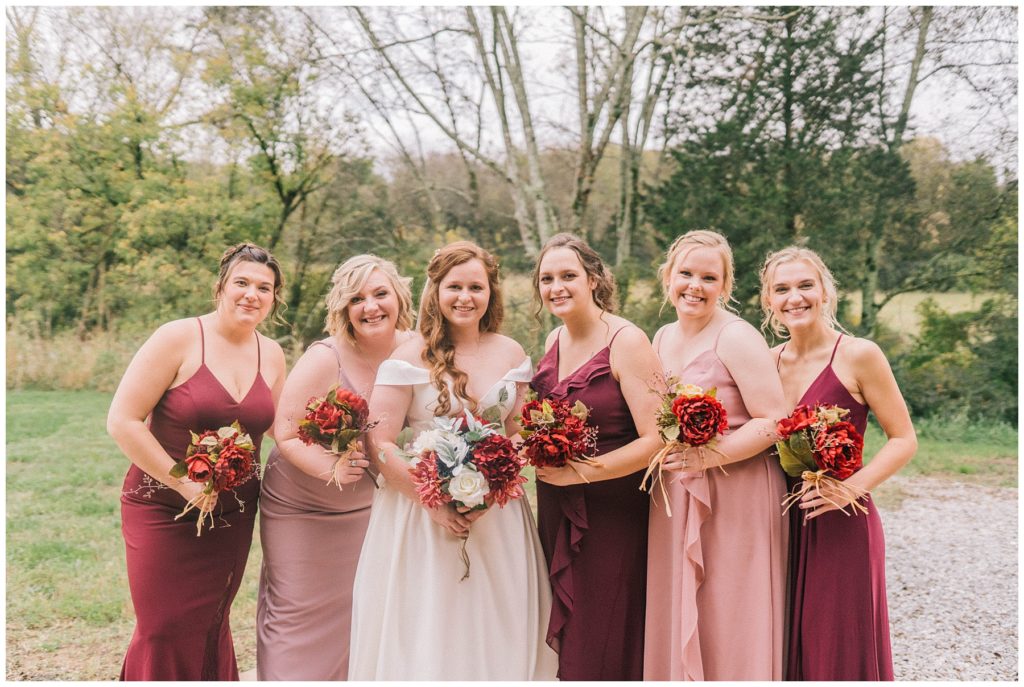 bride with all of her bridesmaids celebrating her on her wedding day