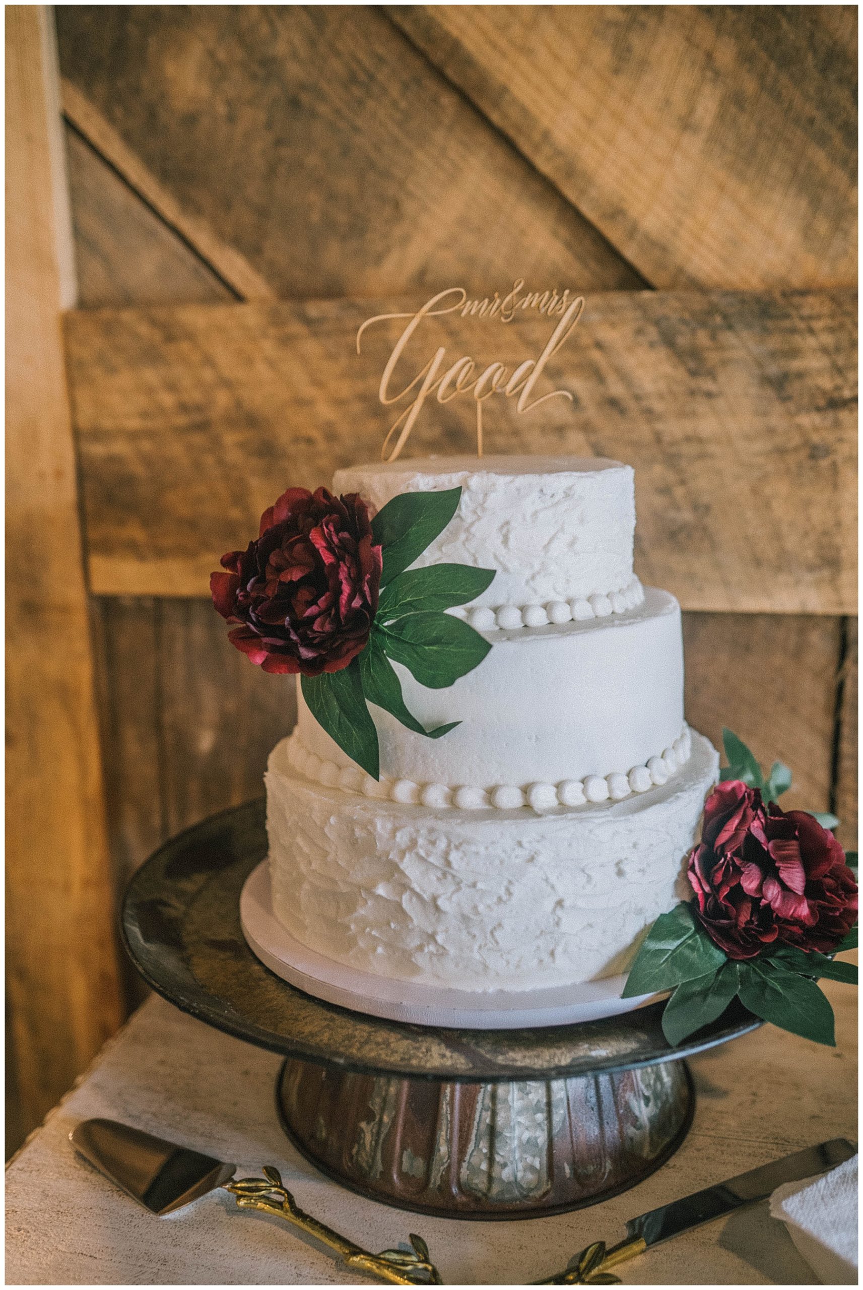 ivory wedding cake with red flowers and greenery for knoxville wedding