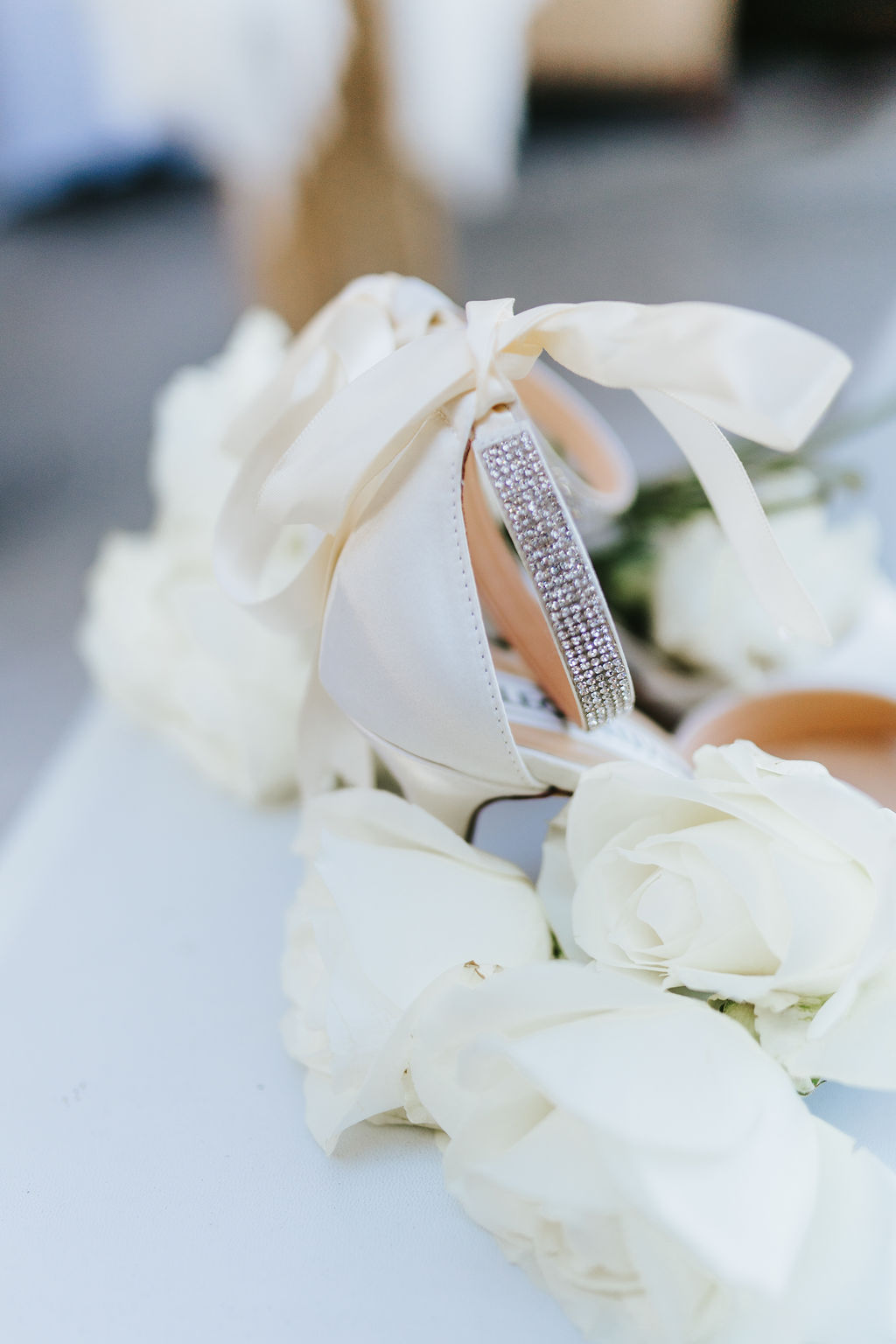detail shot of bridal shoes and white roses