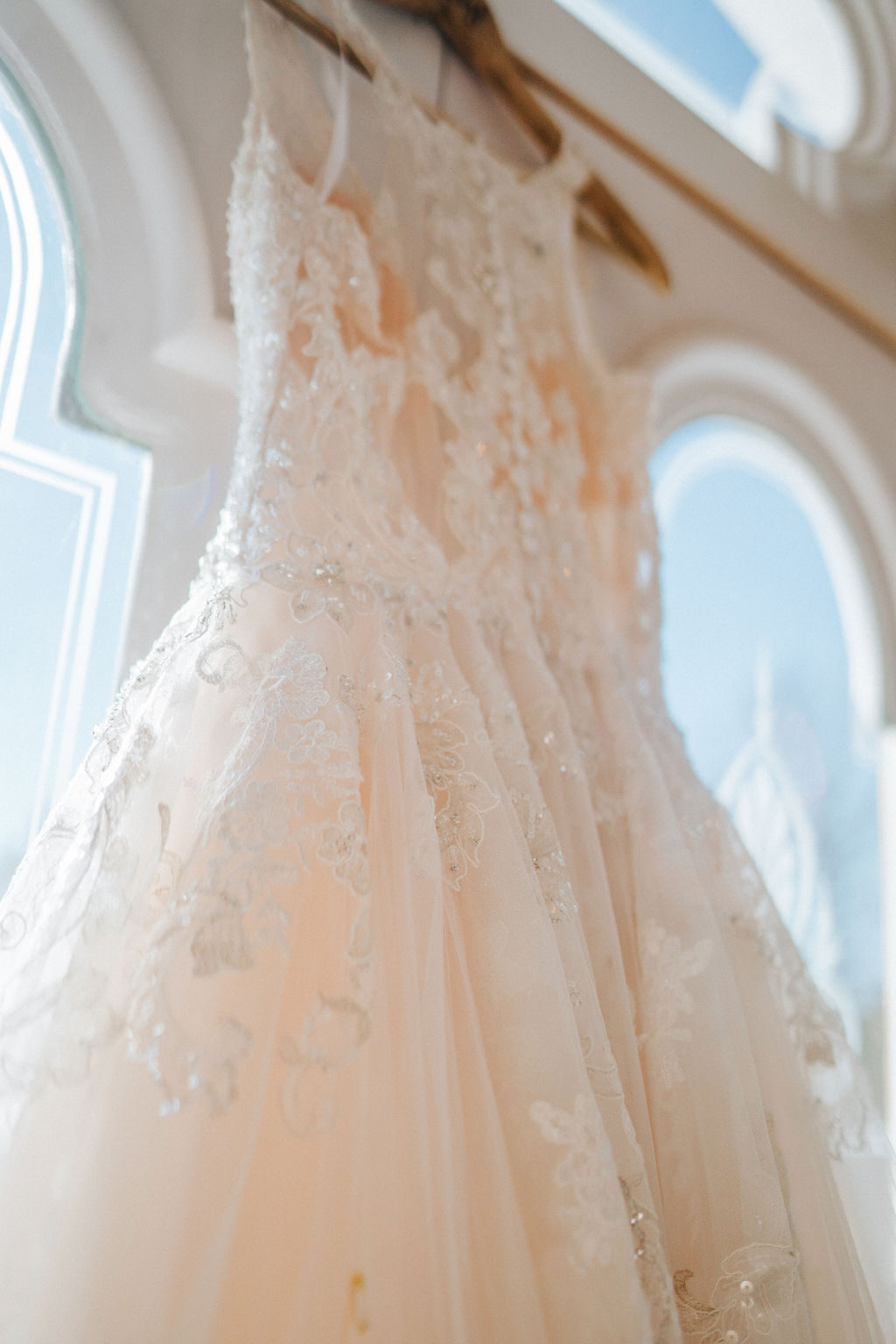 Detailed picture of wedding dress that is hanging from a door