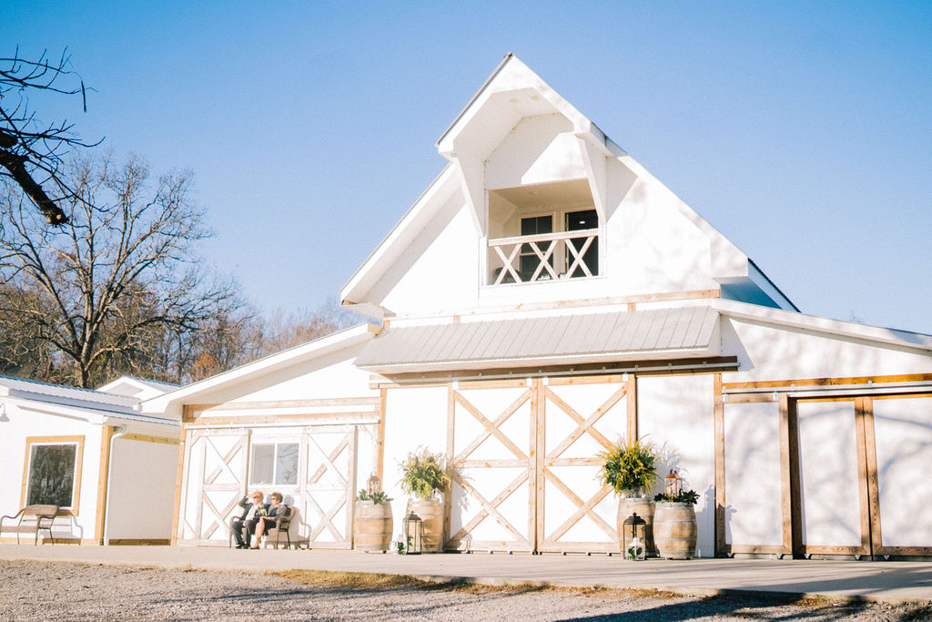 wedding venue in Tennessee that is a large white barn with light wooden details and trimming 