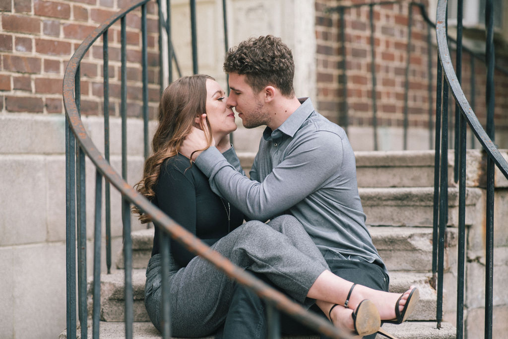 man and woman kissing on spiral staircase in knoxville during engagement session 