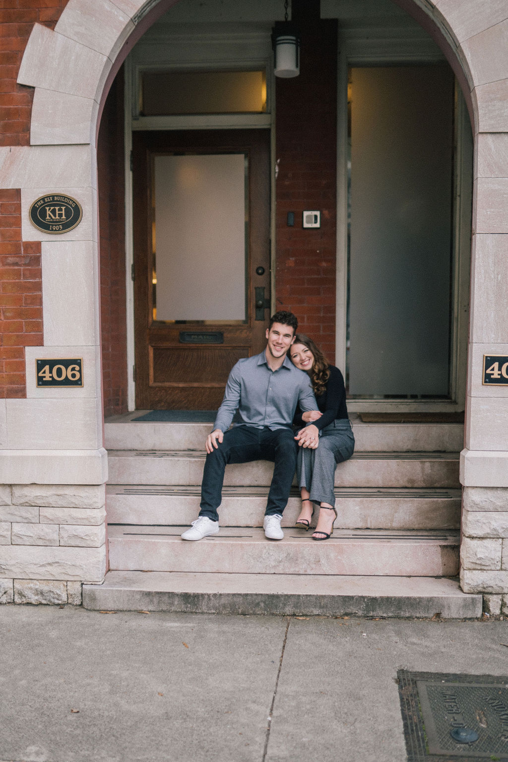 couple sitting on stairs in downtown knoxville celebrating recent engagement