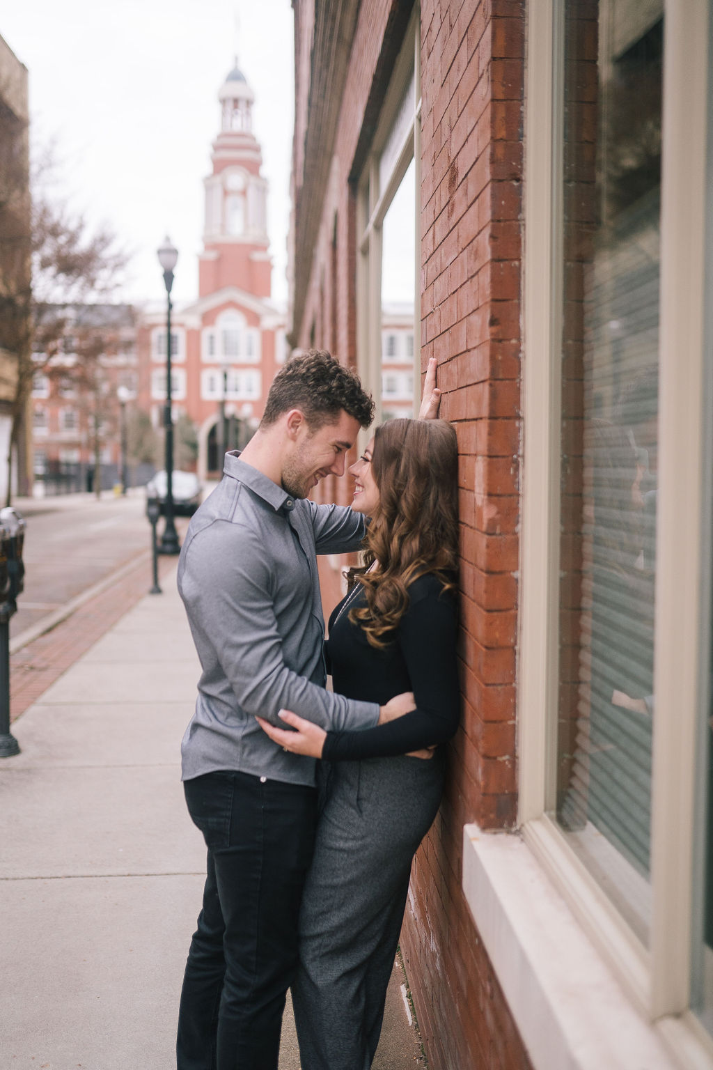 man and woman leaned up against brick wall kissing in tennessee