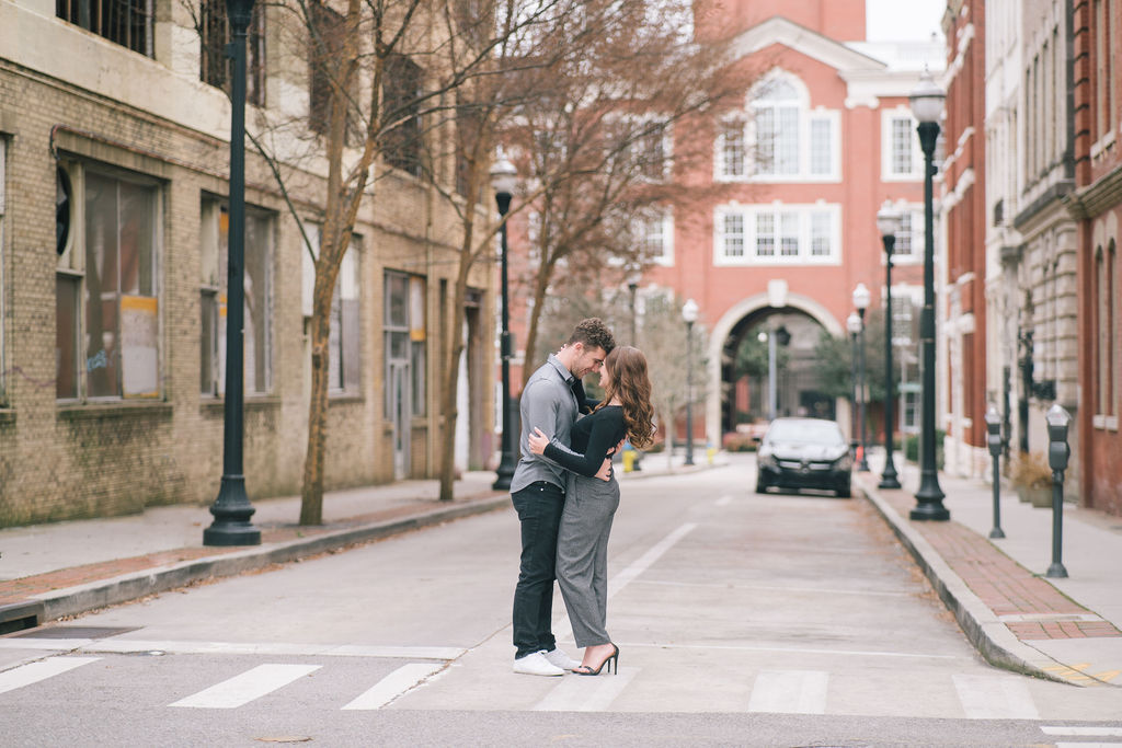 newly engaged couple kissing in the streets of downtown knoxville during engagements session