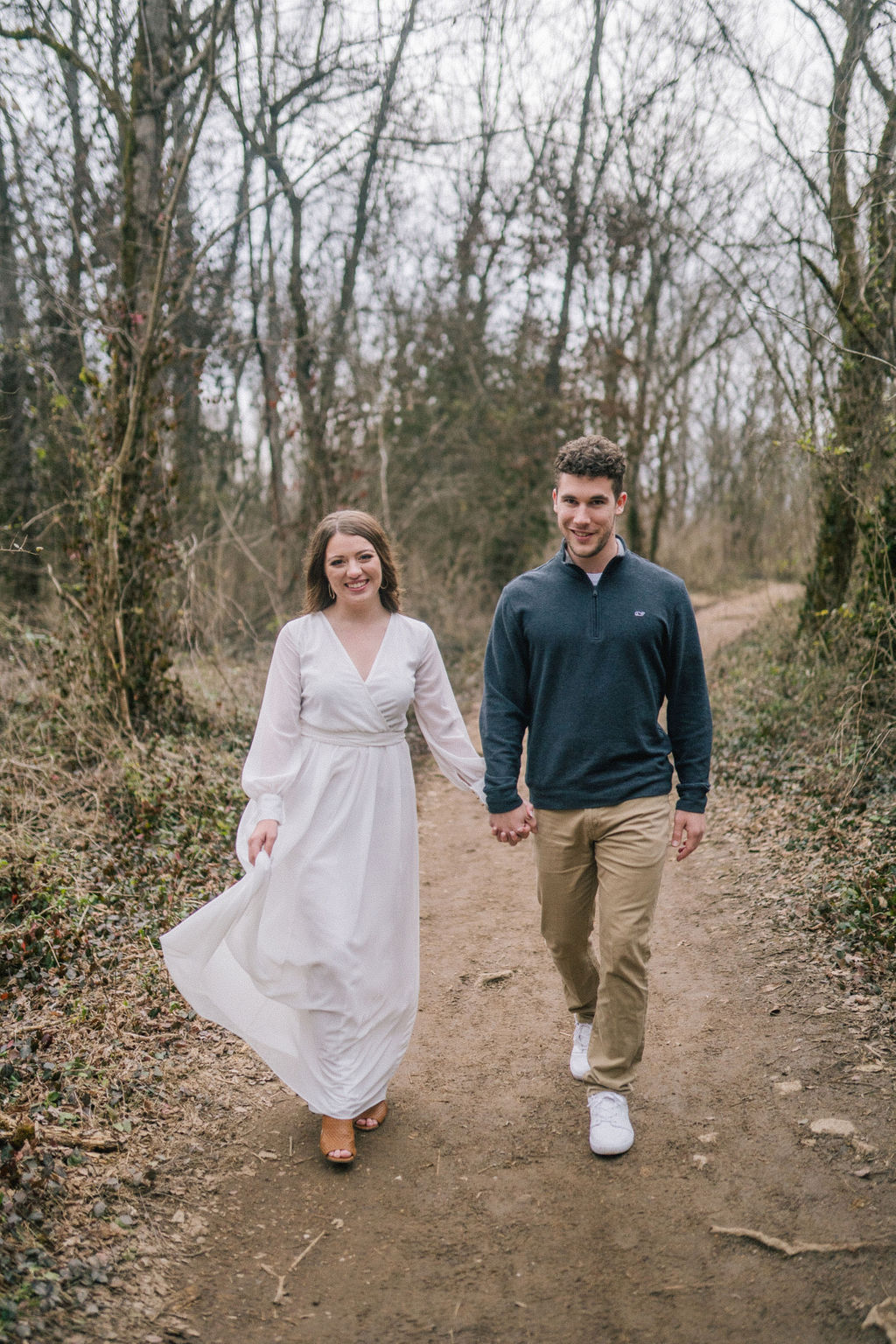 couple walking through knoxville forest during engagement session